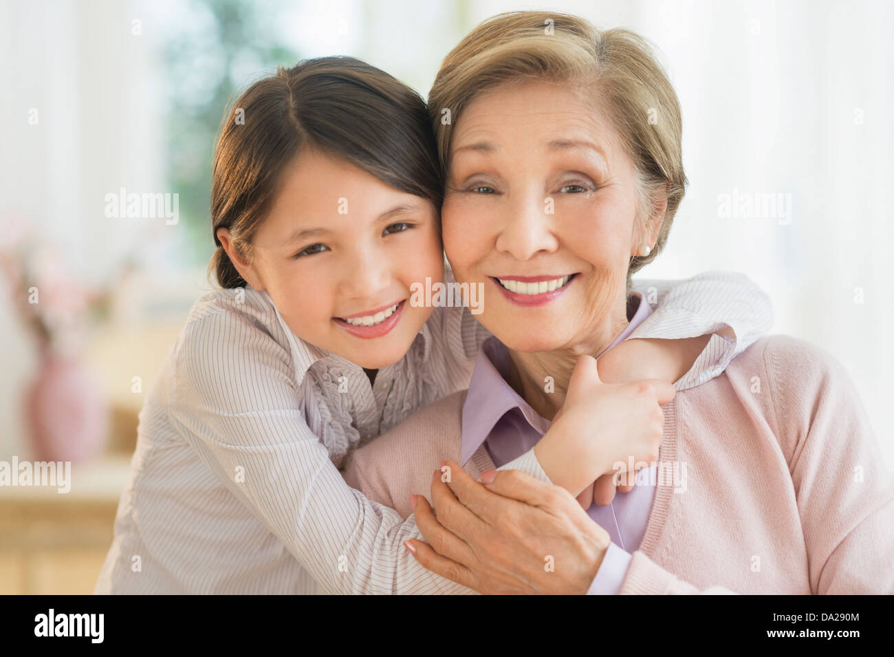 La nipote (8-9) che abbraccia la nonna Foto Stock