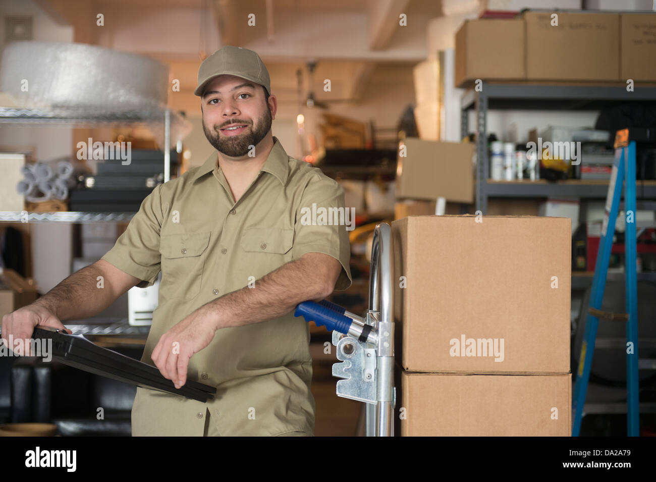 Ritratto di uomo di consegna nel magazzino Foto Stock