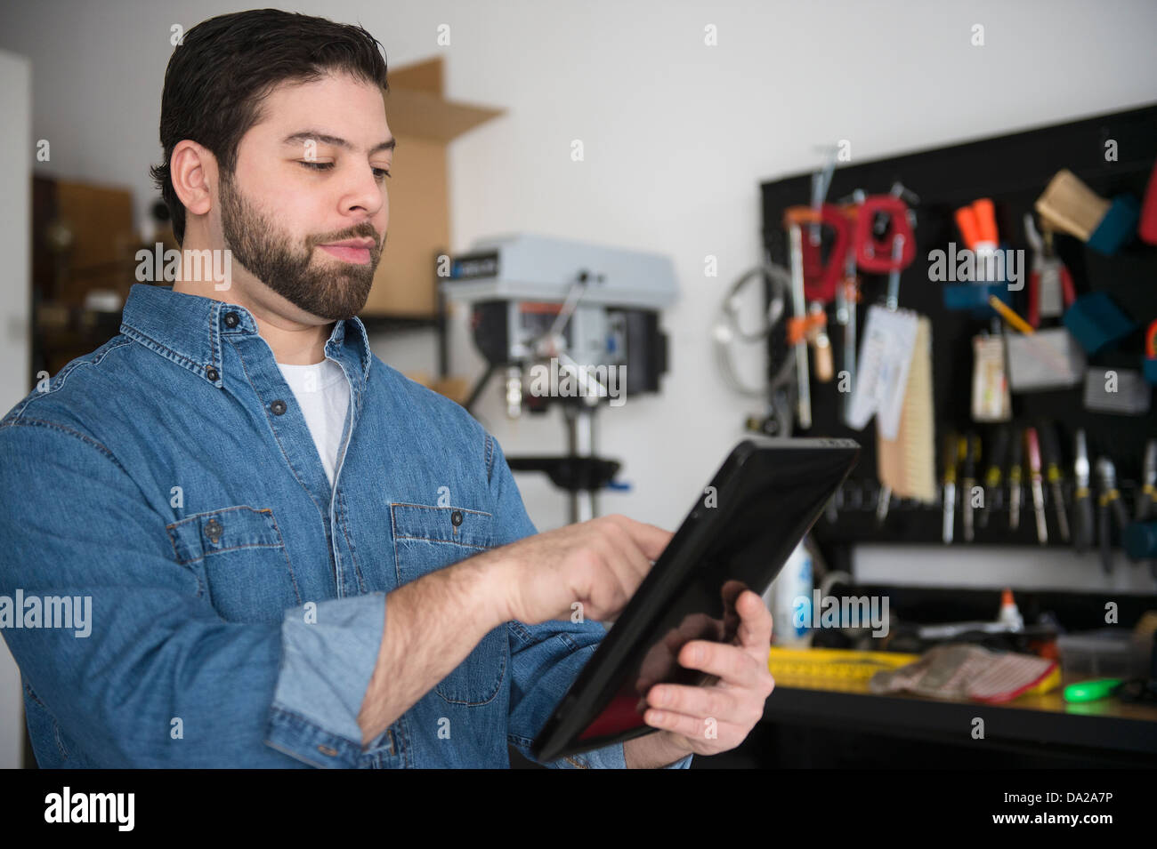 Ritratto di uomo con tavoletta digitale in officina Foto Stock