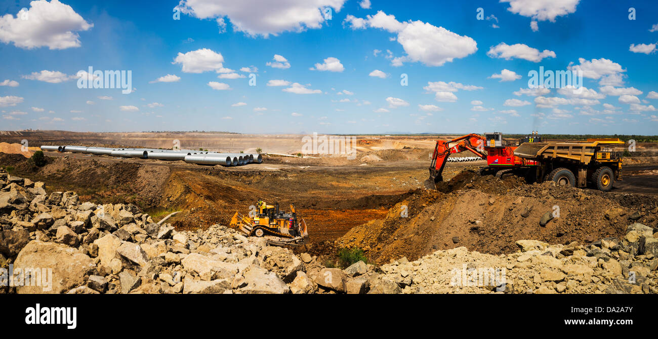 Panorama di un escavatore, escavatore carrello della lama apripista e lavorando su un canale sotterraneo su un sito minerario Foto Stock