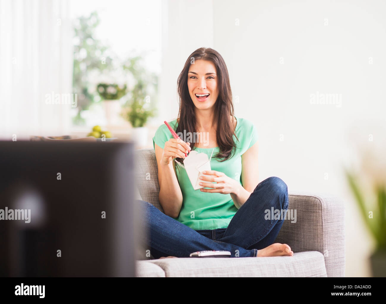 Ritratto di donna di guardare la tv e mangiare prendere il cibo Foto Stock