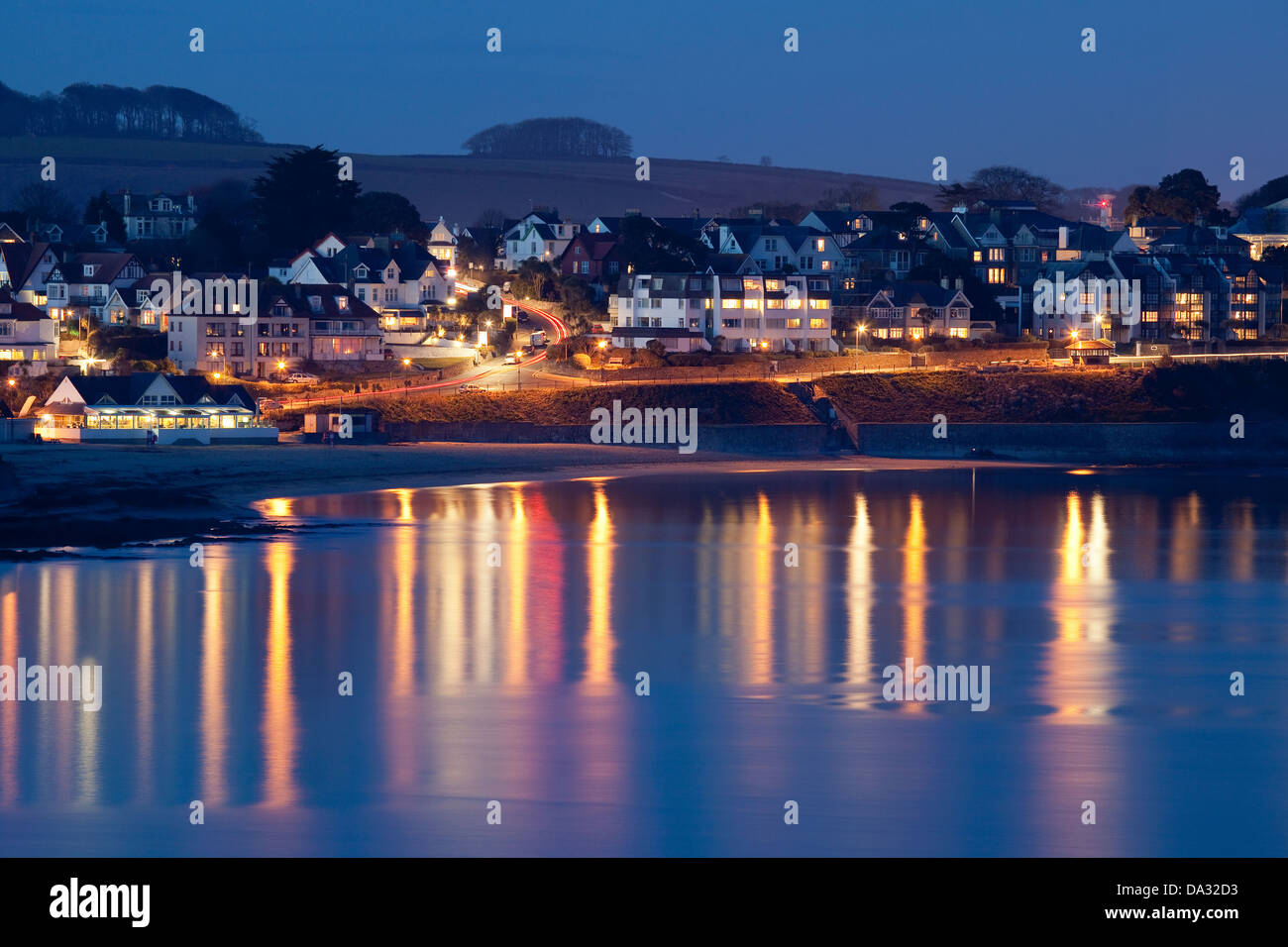 Le luci della città riflettono le acque calme dell'oceano, verso la spiaggia di Gylly e l'edificio circostante di Falmouth di notte. Cornovaglia Inghilterra Foto Stock