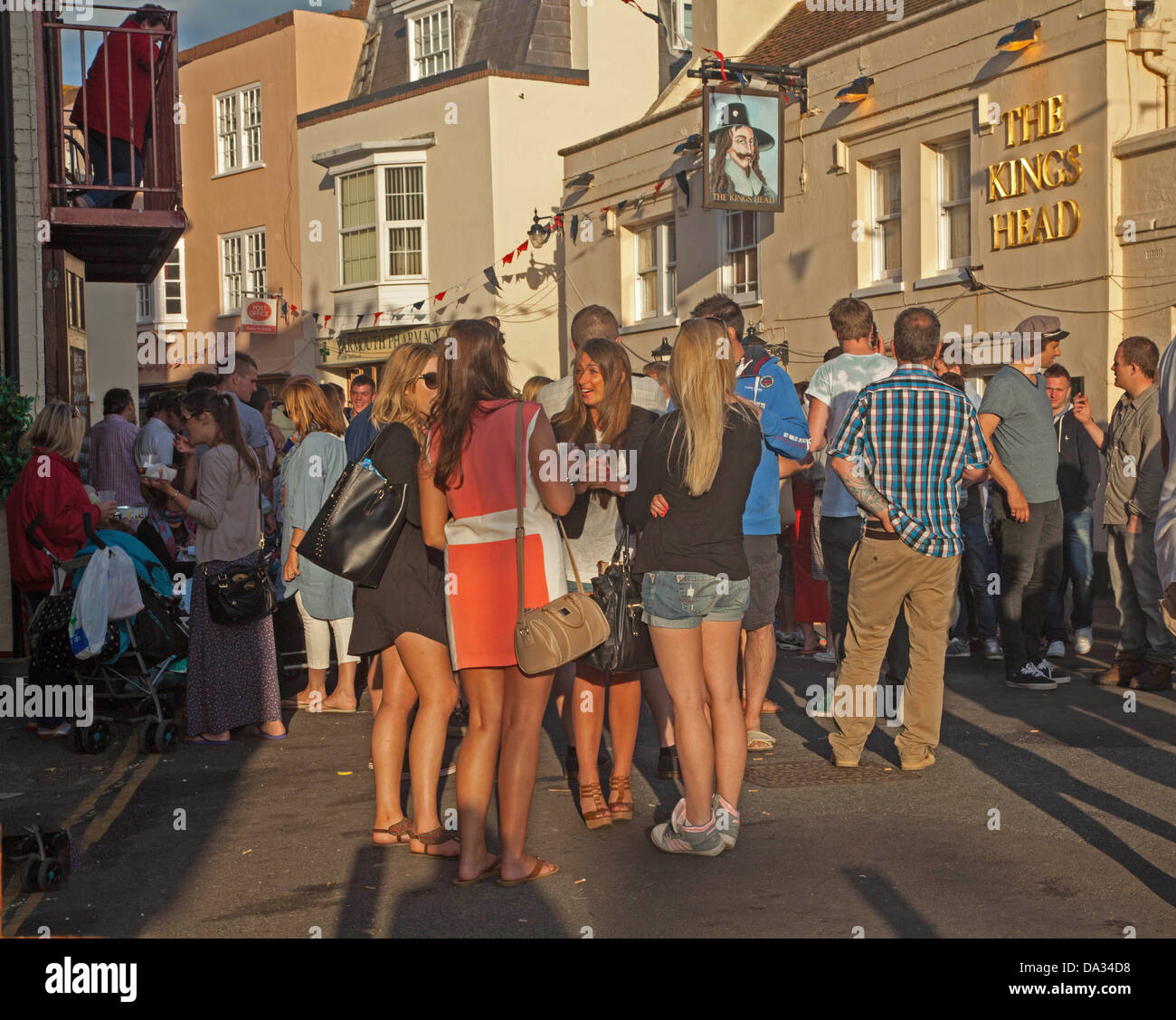 Un gruppo di giovani che si diverte al di fuori di un pub a Yarmouth Isola di Wight Foto Stock