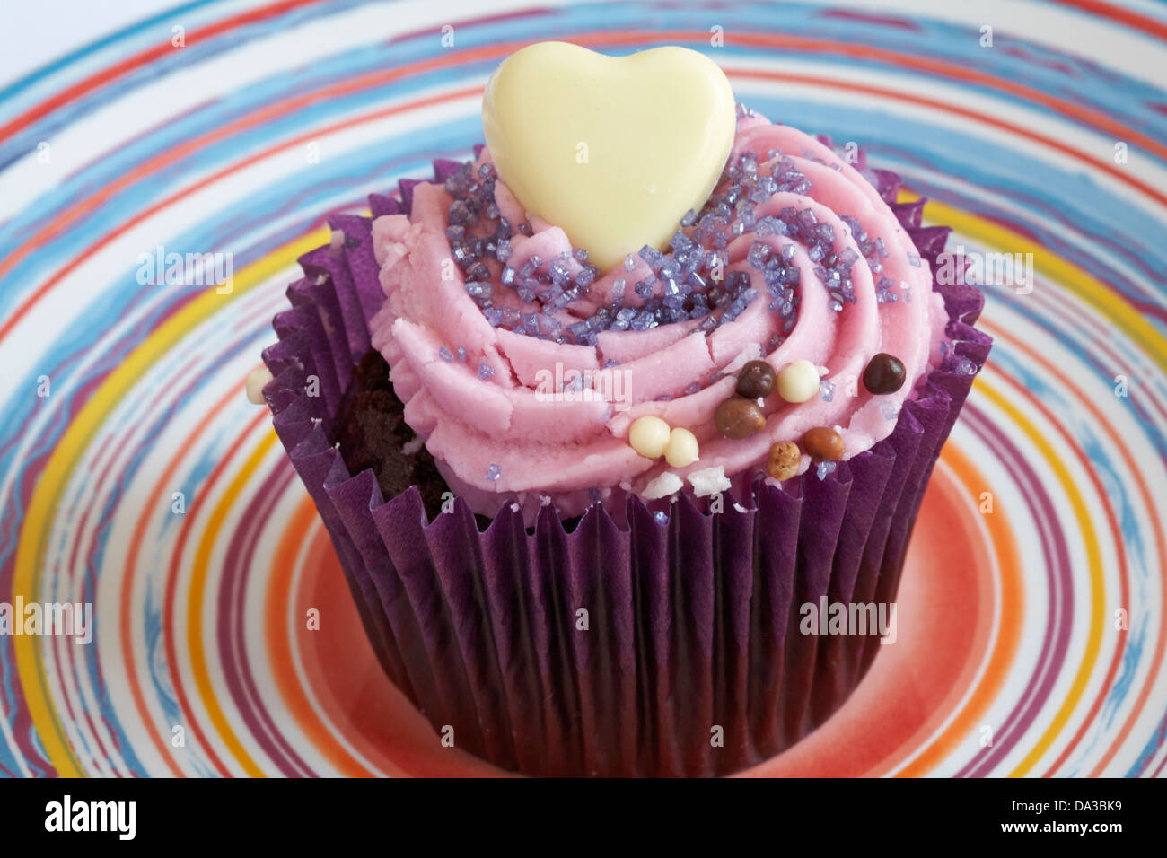 Blackberry tortina con il cioccolato bianco Cuore e commestibile glitter sulla piastra colorati Foto Stock