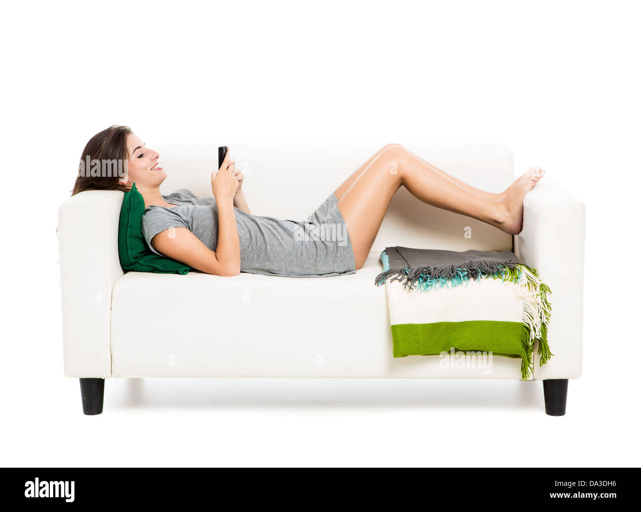 Bella donna su un divano bere il tè, isolato su uno sfondo bianco Foto Stock