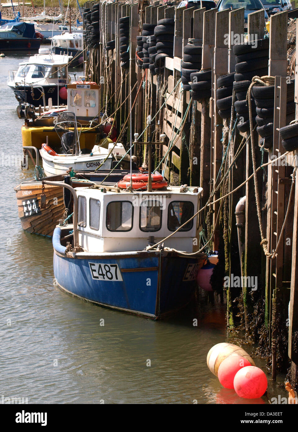 Commerciali di piccole barche da pesca ormeggiate contro la parete del porto, Axmouth Harbour, Seaton, Devon, Regno Unito 2013 Foto Stock