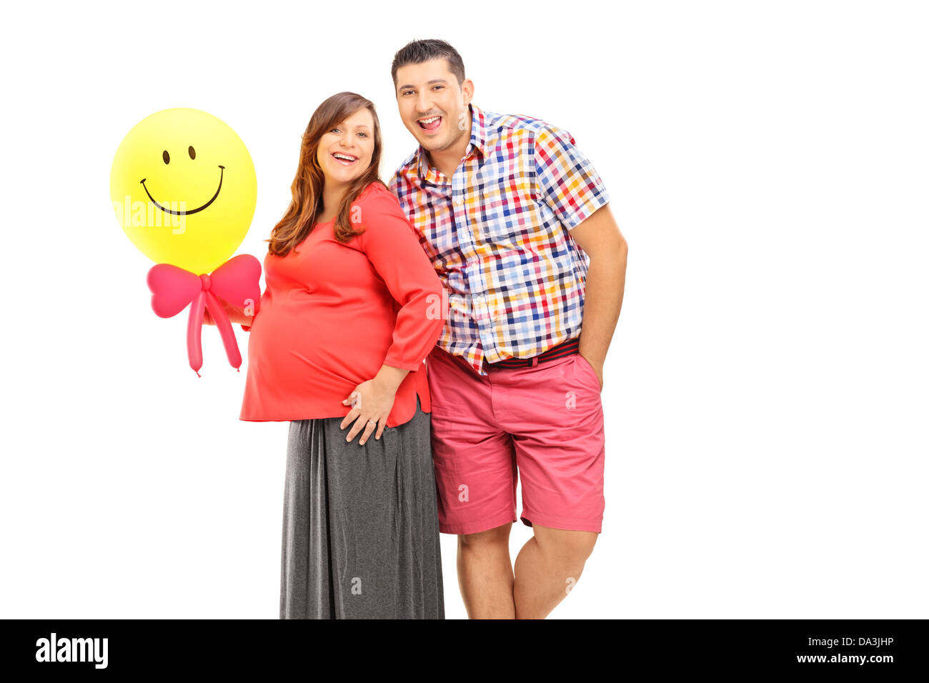 Coppia felice in attesa di un bambino e tenendo un palloncino isolati su sfondo bianco Foto Stock