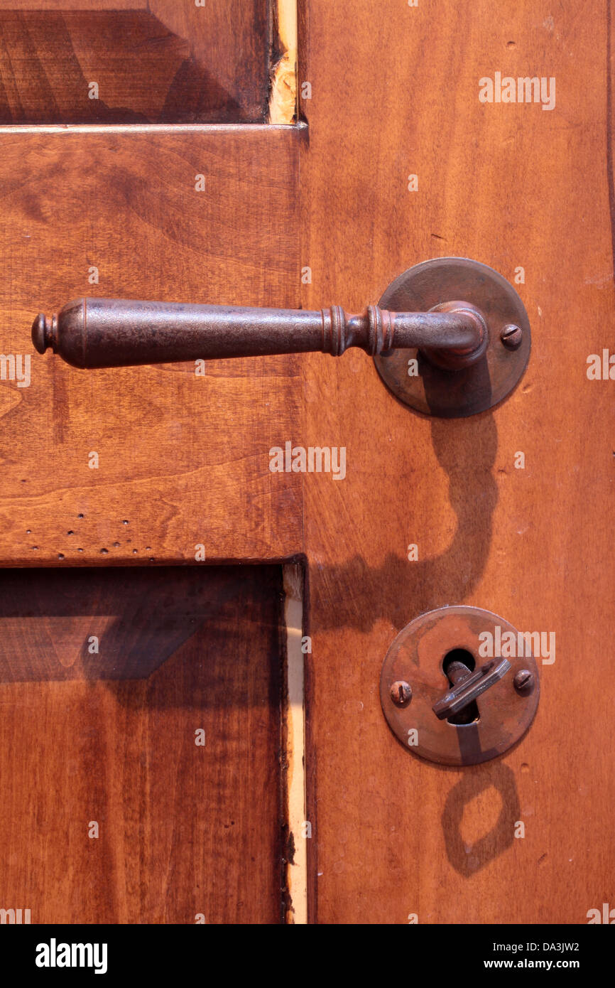 Ferro da stiro maniglia della porta su una vecchia porta di legno Foto Stock