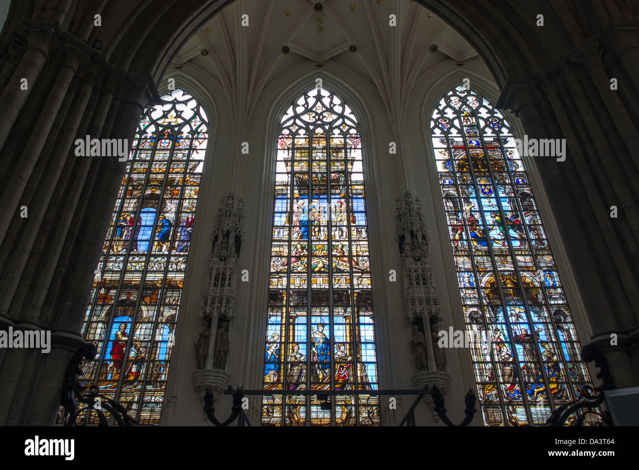 BRUXELLES, Belgio — tre strette vetrate colorate presso la cattedrale di San Michele e San Gudula (in francese, Co-Cathédrale collégiale des SS-Michel et Gudule). Una chiesa fu fondata su questo sito nell'XI secolo, ma l'attuale edificio risale al XIII-XV secolo. La cattedrale cattolica romana è la sede di molte funzioni statali come incoronazioni, matrimoni reali e funerali di stato. Ha due santi patroni, San Michele e San Gudula, entrambi i quali sono anche i santi patroni di Bruxelles. Foto Stock