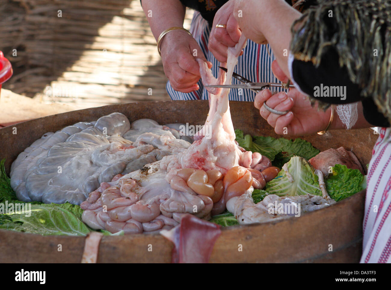 Donne preparano pezzi di carne di maiale per riempire le salsicce e altre carni in una fiera locale in Mallorca Foto Stock