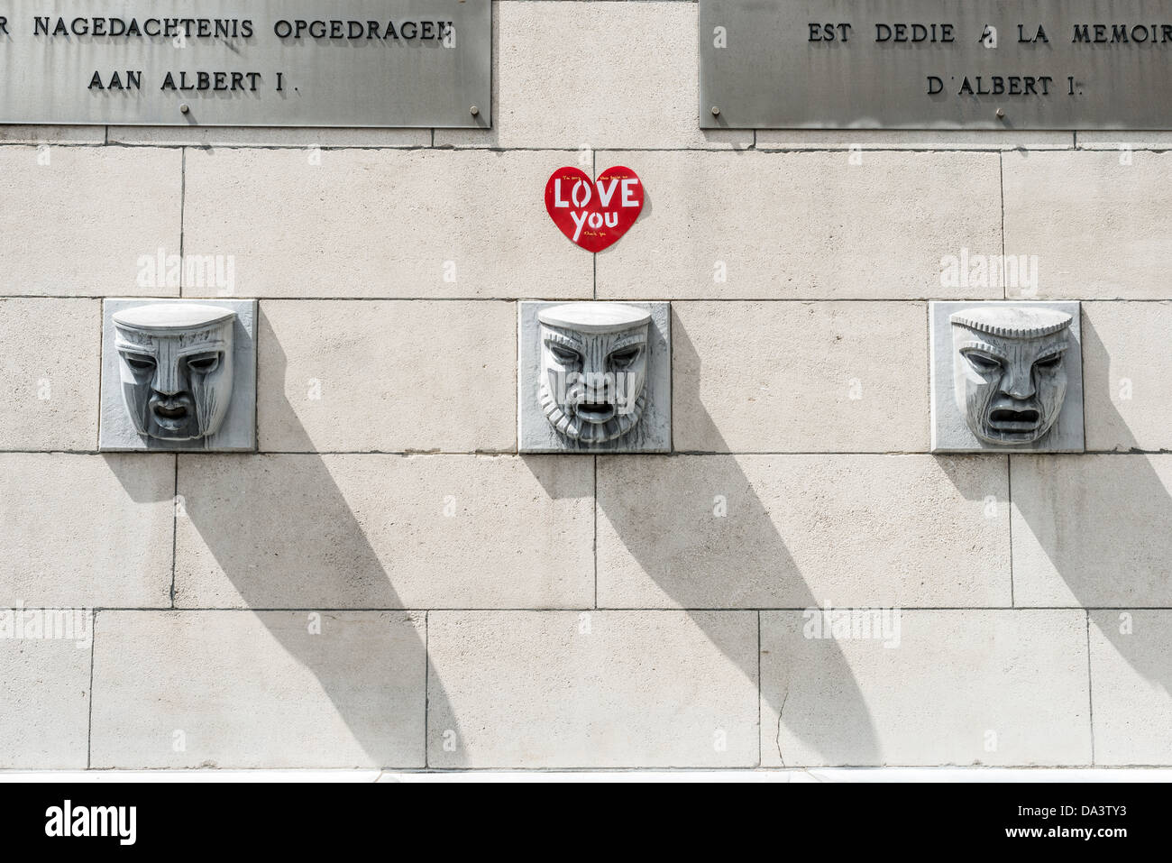 Una scultura a parete di tre facce stilizzate al Mont des Arts di Bruxelles in Belgio. Foto Stock