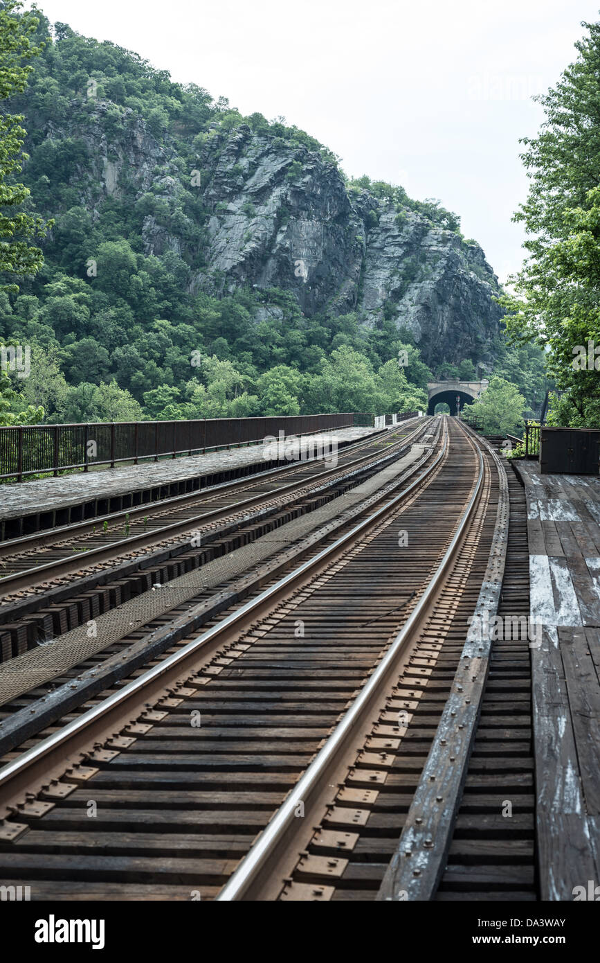 Railroad Bridge Harpers Ferry West Virginia // HARPERS FERRY, West Virginia, Stati Uniti - i binari della ferrovia attraversano il fiume Potomac da Harpers Ferry, West Virginia, nel Maryland. Lo storico ponte ferroviario fa parte del paesaggio panoramico dove si incontrano i fiumi Potomac e Shenandoah, circondato dalle Blue Ridge Mountains. Questo hotel si trova all'interno del parco storico nazionale di Harpers Ferry, un luogo ricco di storia della guerra civile e bellezze naturali. Foto Stock