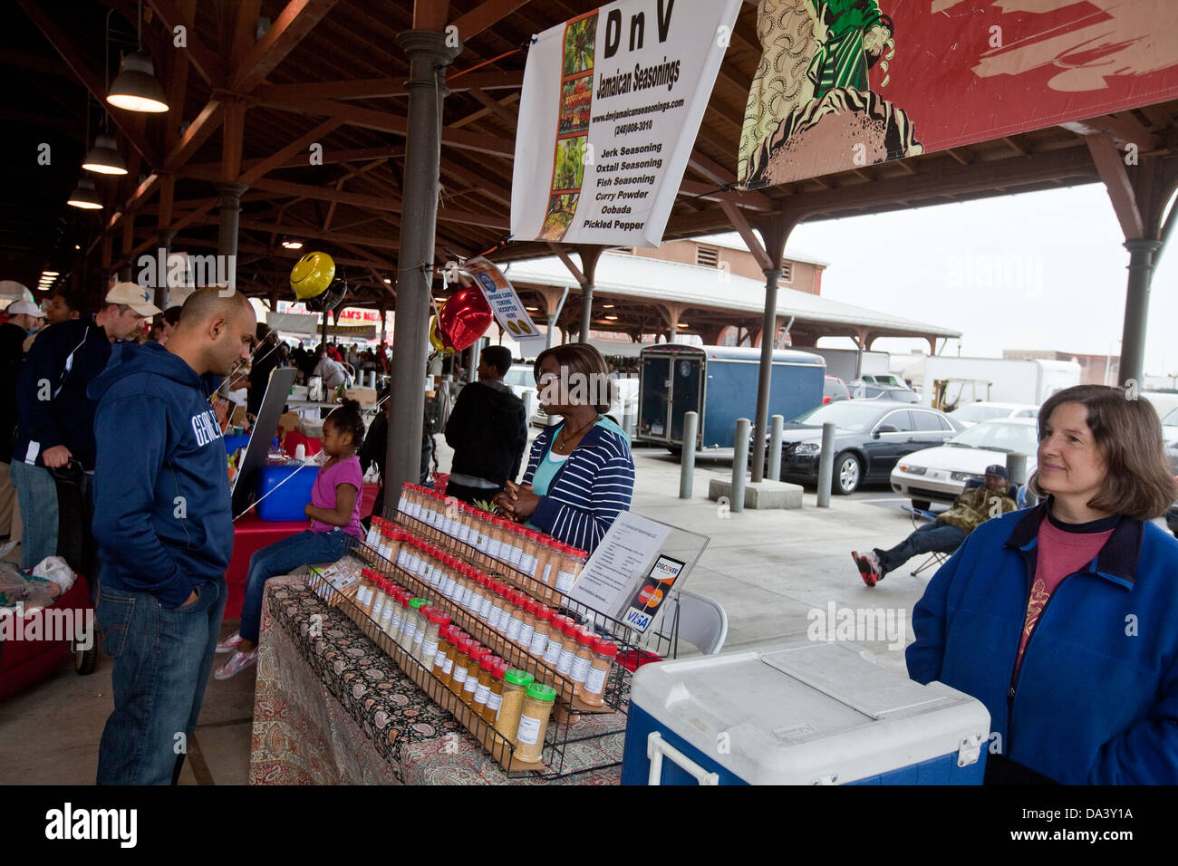 Un uomo peruses lo stallo di un venditore a vendere il giamaicano condimenti a Detroit orientale il mercato degli agricoltori a Detroit (MI) Foto Stock