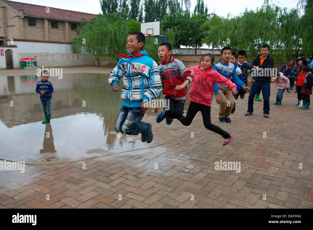 Gli studenti giocare saltando durante le pause in una scuola primaria in Haiyuan, Ningxia, Cina. 21-Maggio-2013 Foto Stock