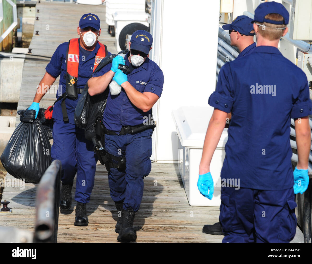 I membri dell'equipaggio a Stazione della Guardia Costiera Miami Beach, Florida, offload circa 1.250 libbre di cocaina che vale la pena un valore stimato di $ 19 milioni di Luglio 1, 2013. L'equipaggio del guardacoste Bertholf interdetto la cocaina durante una pattuglia di routine nel e Foto Stock