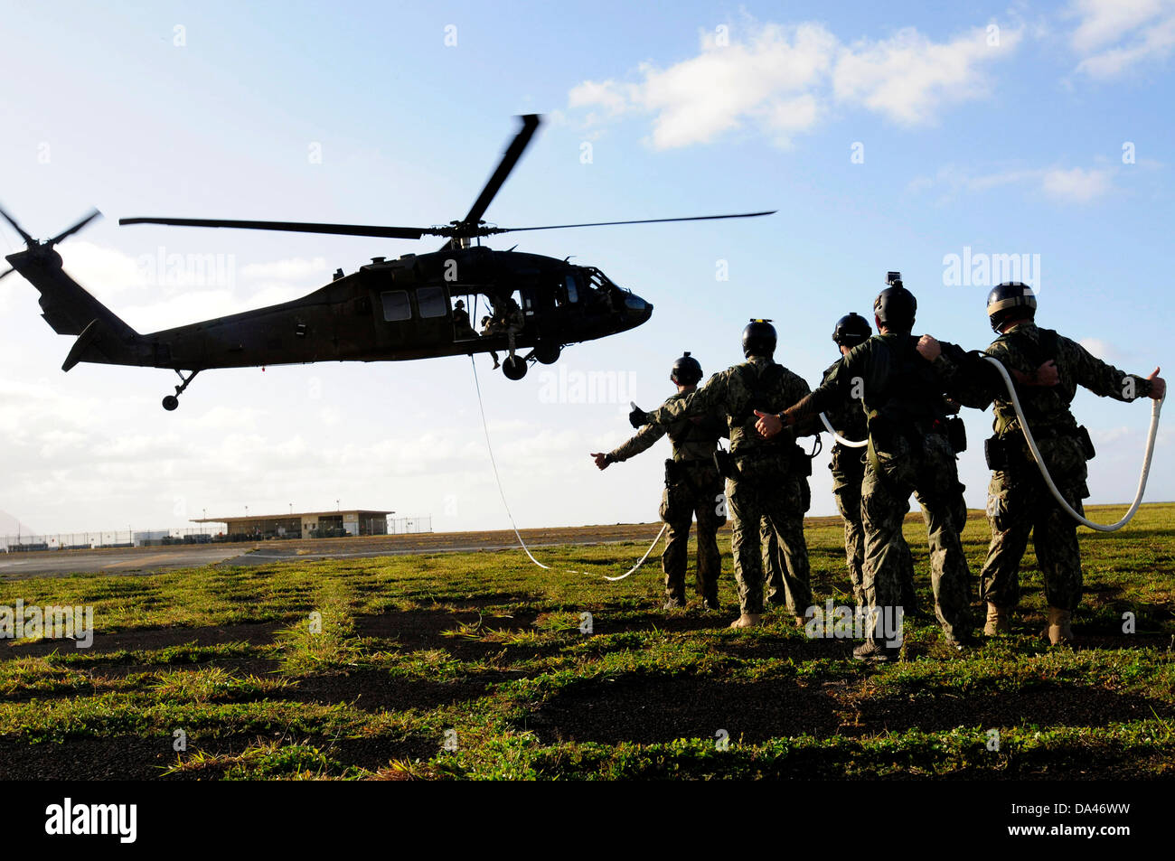 US Navy SEAL membri del team a prepararsi per essere sollevati in aria con una speciale pattuglia di inserimento e di estrazione corda attaccata ad un UH-60 Black Hawk elicottero durante la formazione HELOCAST al Marine Corps Air Station Kaneohe Bay il 19 giugno 2013 nelle Hawaii. Foto Stock