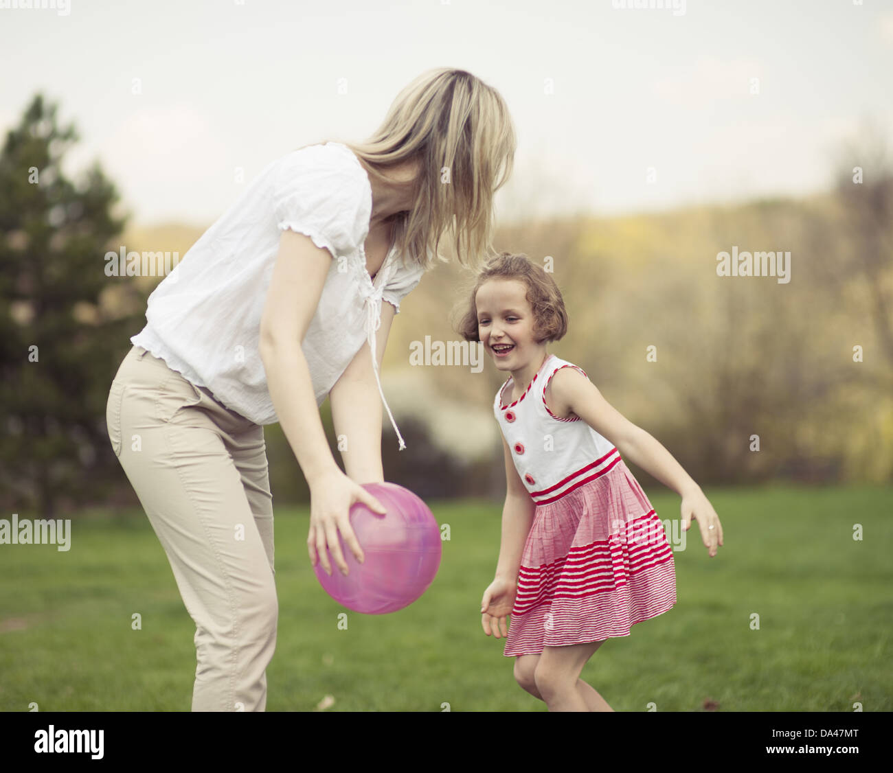 Madre e figlia gioca con la palla nel parco Foto Stock