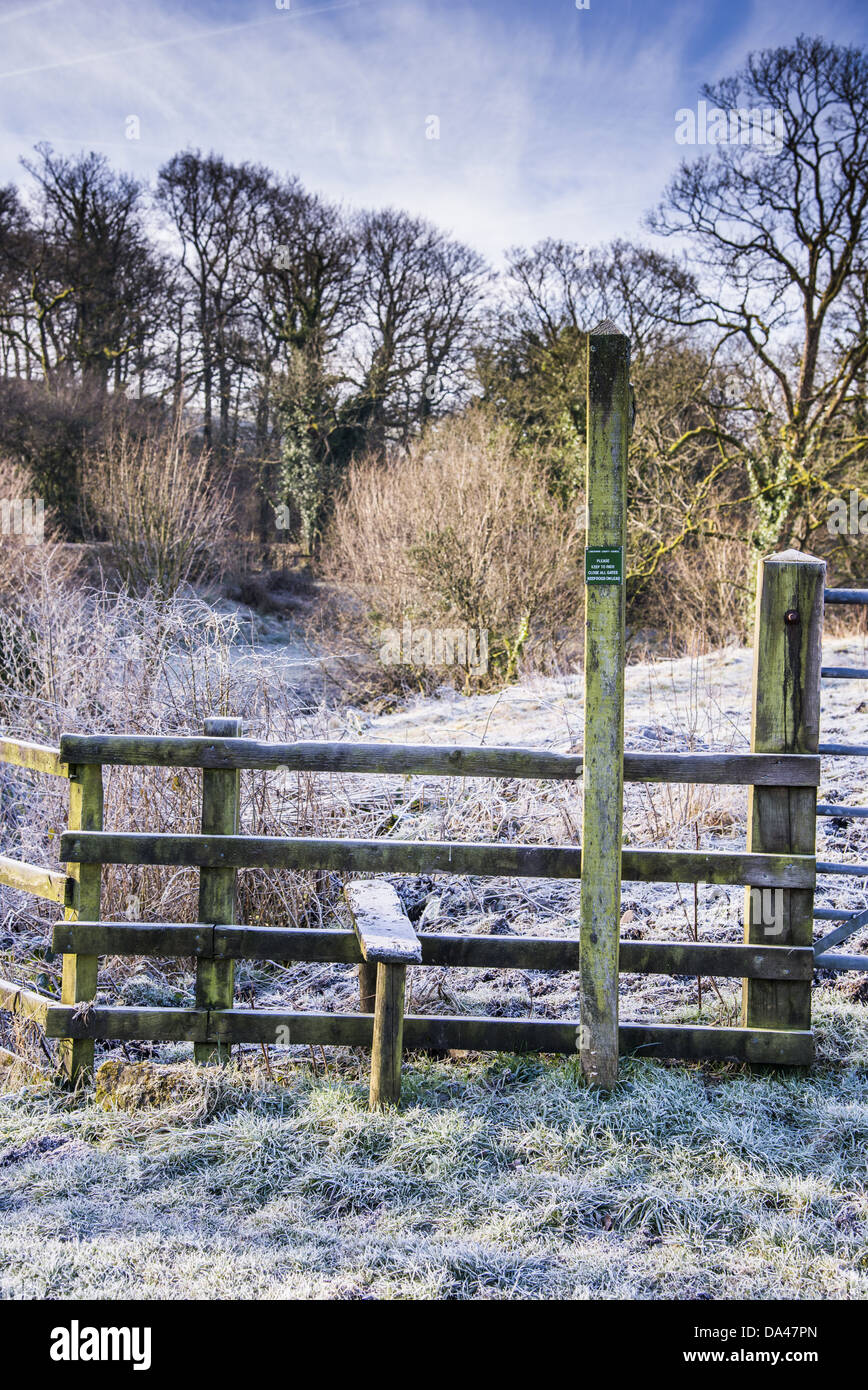 La brina sulla staccionata in legno con stile e "sentiero pubblico' segno vicino Ponte Doeford Whitewell foresta di Bowland Lancashire Inghilterra Foto Stock