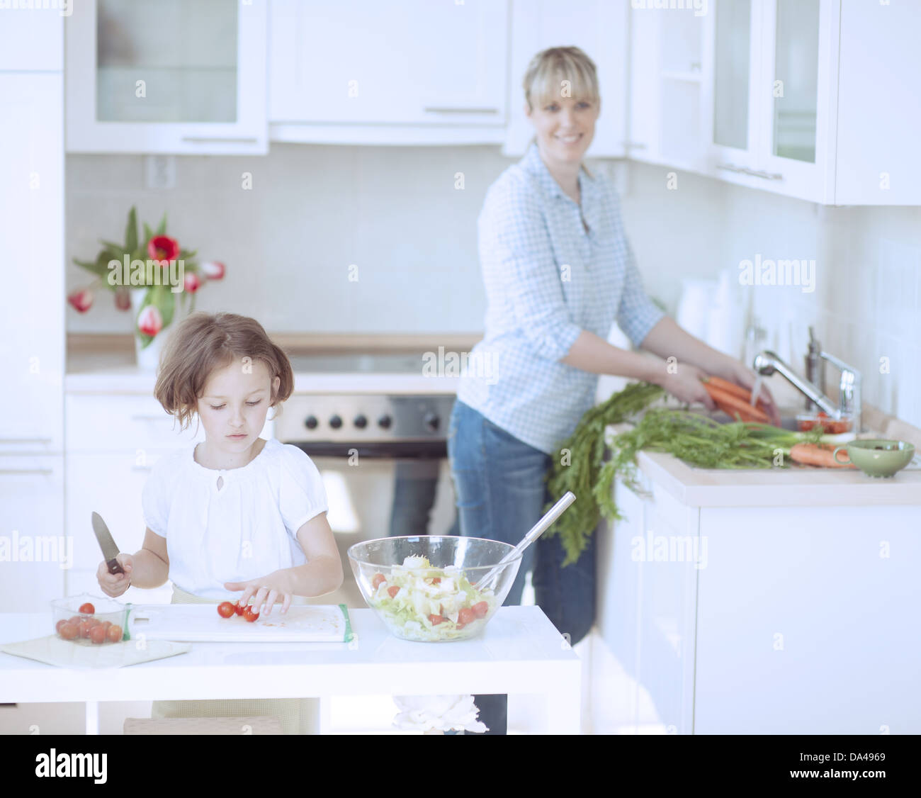 Madre e figlia (8-9) la preparazione di pasto sano in cucina Foto Stock