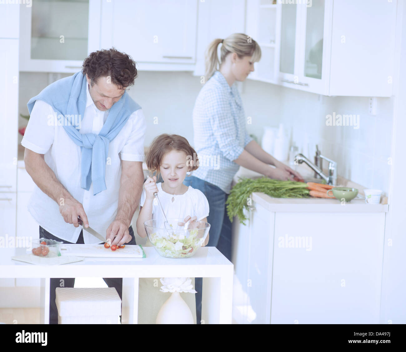 La famiglia la preparazione di pasto sano in cucina Foto Stock
