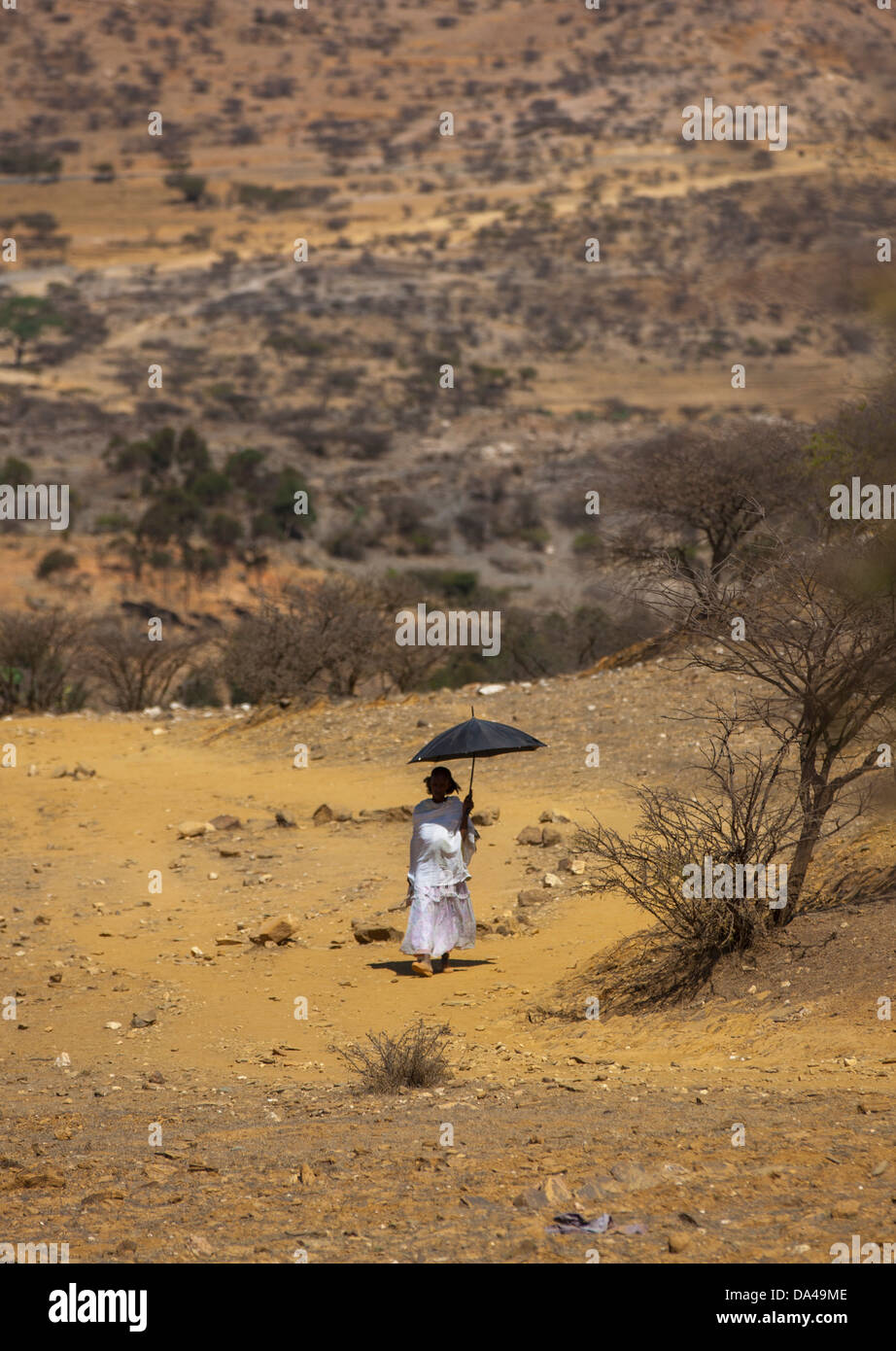Donna che cammina con un Umbrealla, Adi Keyh, Eritrea Foto Stock