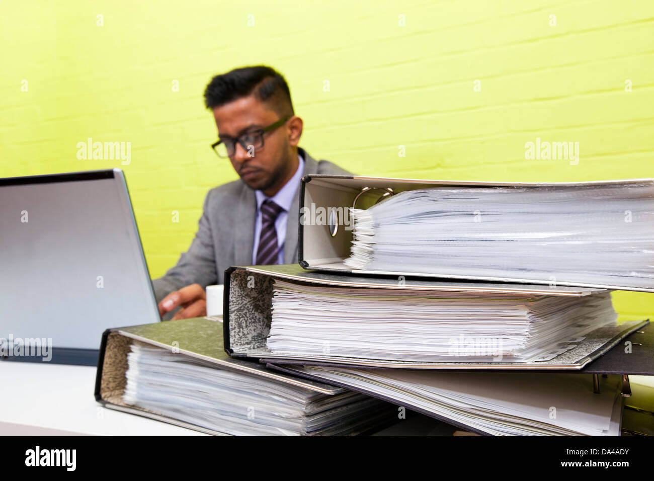 Ritratto di commerciante indiano al lavoro sul suo computer portatile alla sua scrivania Foto Stock