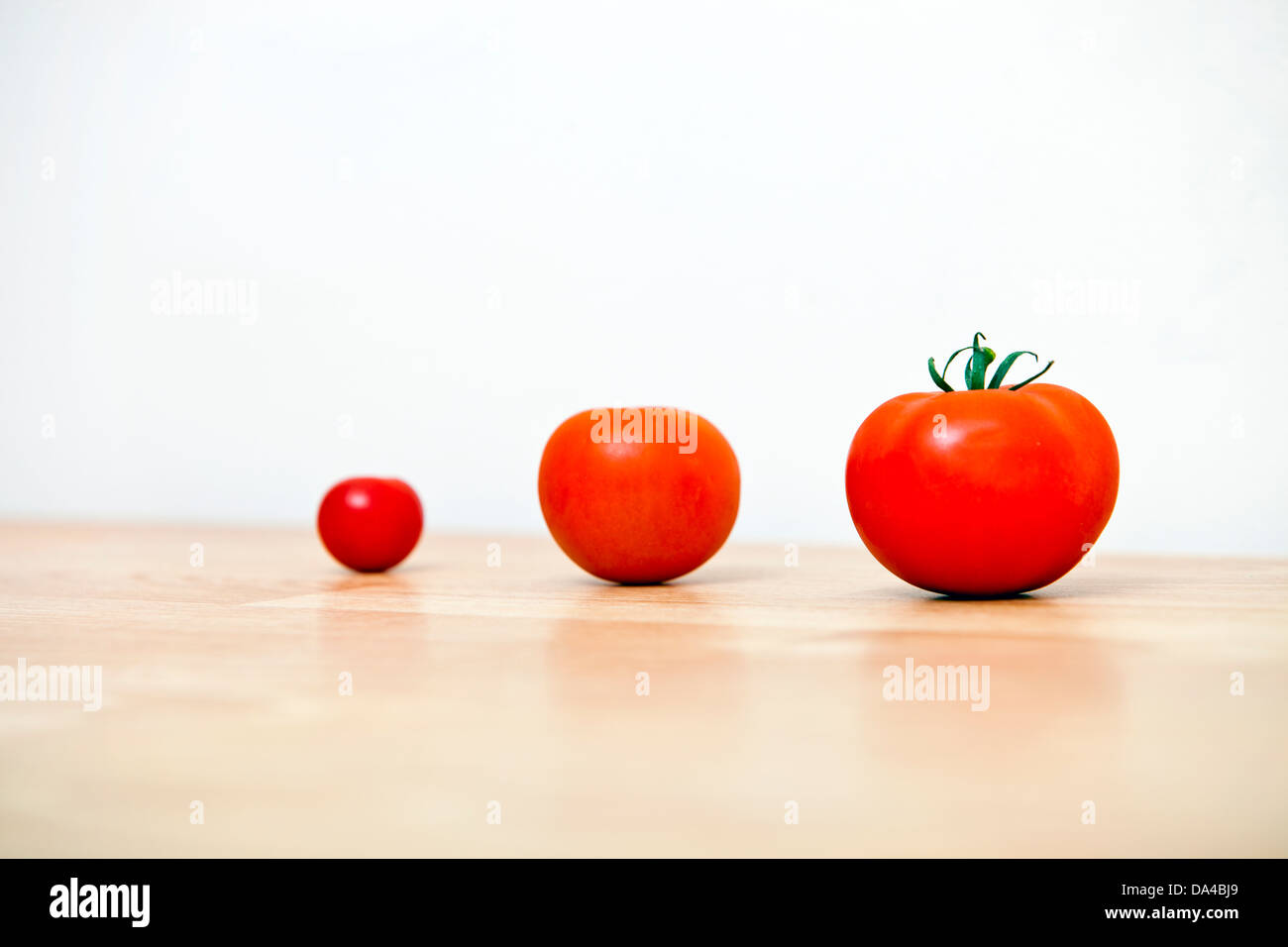 Studio shot di tre pomodori ciliegia in una riga Foto Stock