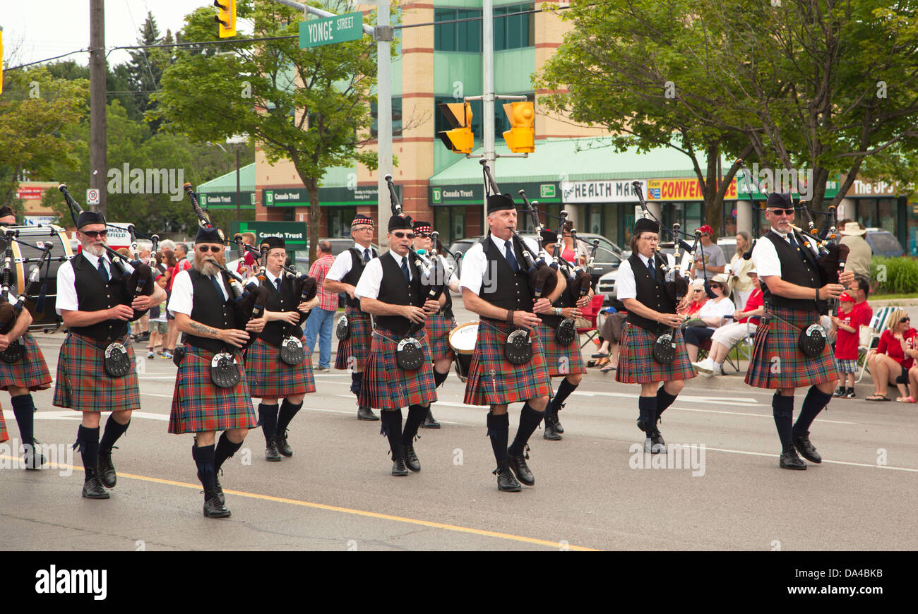 AURORA, Ontario, Canada - 1 luglio: irlandesi nel loro kilt giocano il loro cornamuse durante il Canada parata del giorno in corrispondenza di una parte di giovani str Foto Stock