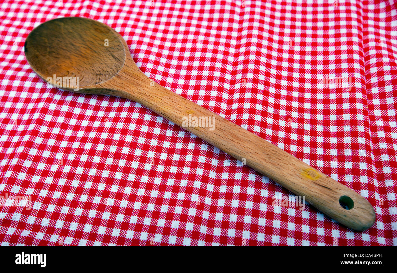 Cucchiaio di legno vicino fino a un rosso e tovaglie bianche Foto Stock