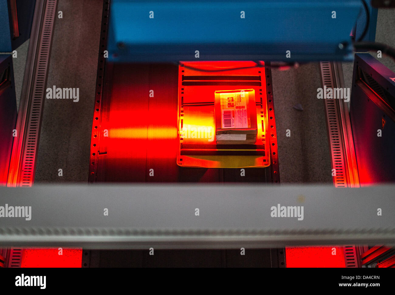 Lo scanner legge il codice a barre di un pacco su un nastro trasportatore alla recente apertura di spedizioni hub di DHL a Berlino, Germania, 3 luglio 2013. La struttura ha la capacità di elaborare fino a 8000 pacchetti e pacchi al giorno. Foto: Hannibal Hanschke Foto Stock