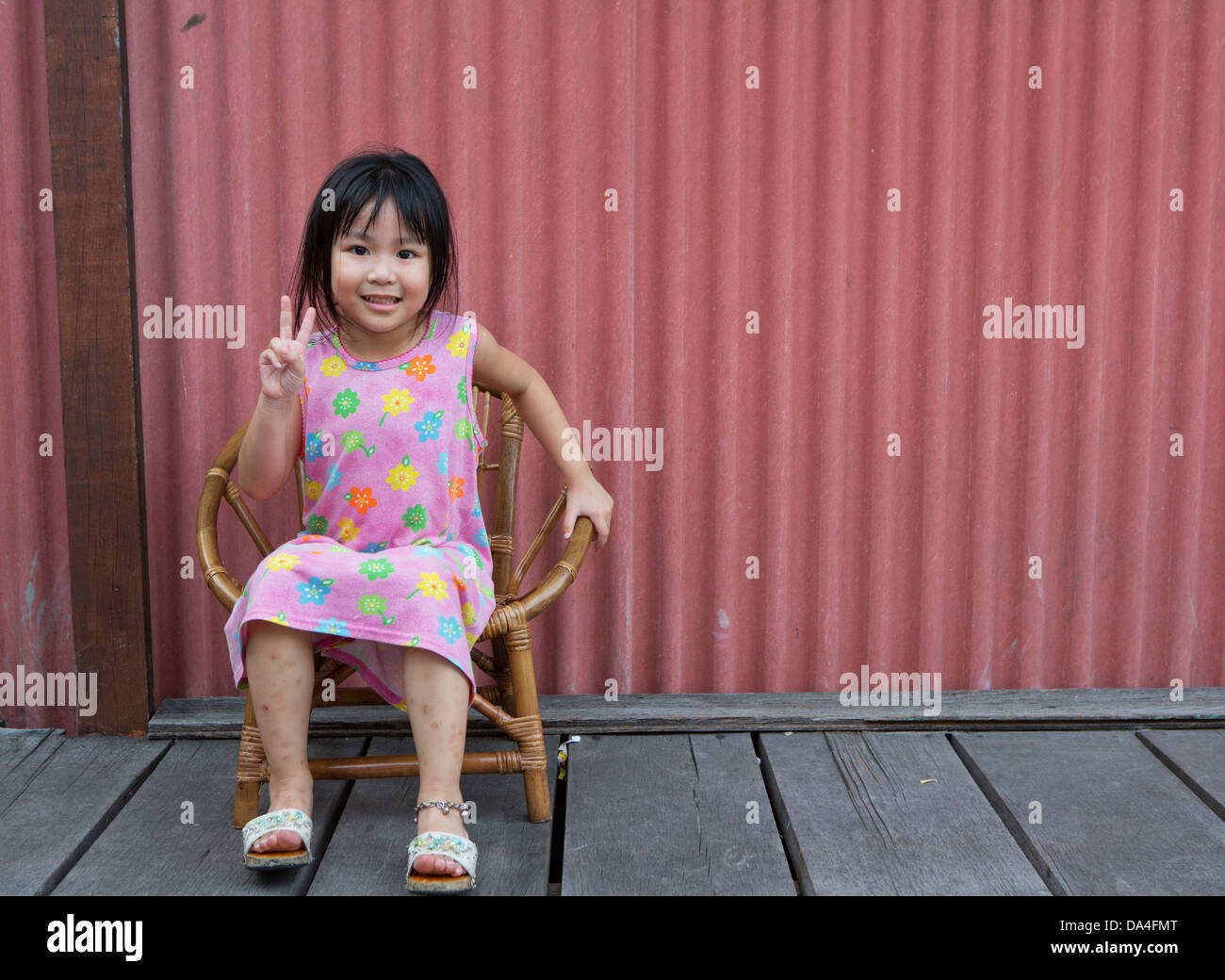 Bambina seduti sulla sedia sorridente clan di saldatura Quay Piers, Georgetown, Penang, Malaysia Foto Stock
