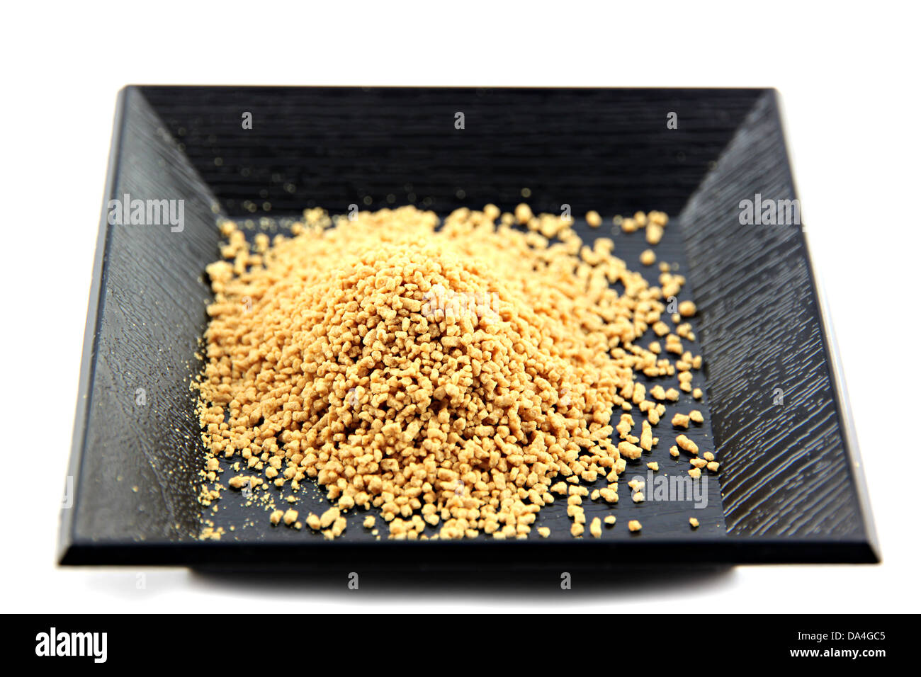 Lo zenzero in polvere in piatto nero su uno sfondo bianco. Foto Stock