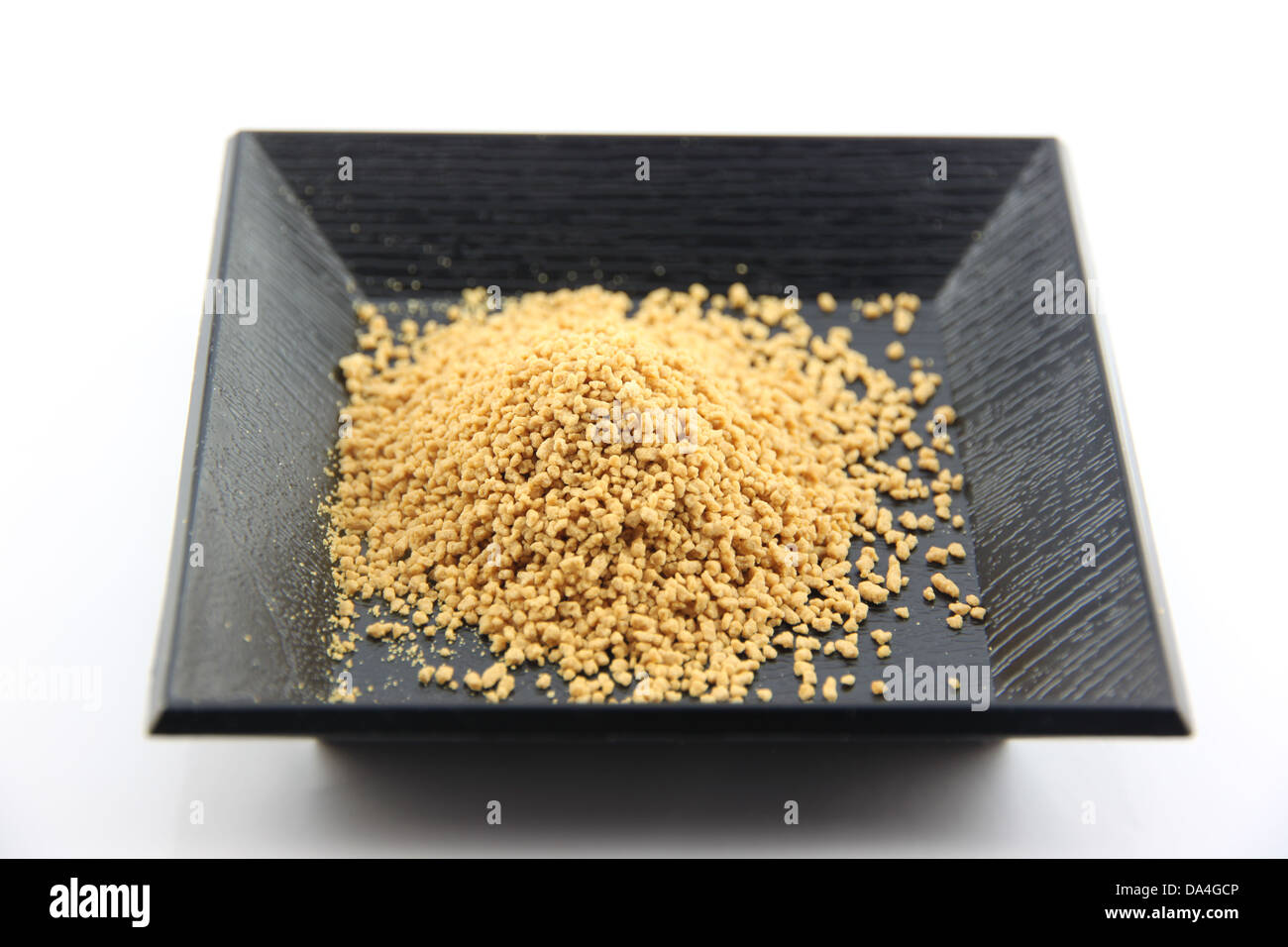 Lo zenzero in polvere in piatto nero su uno sfondo bianco. Foto Stock