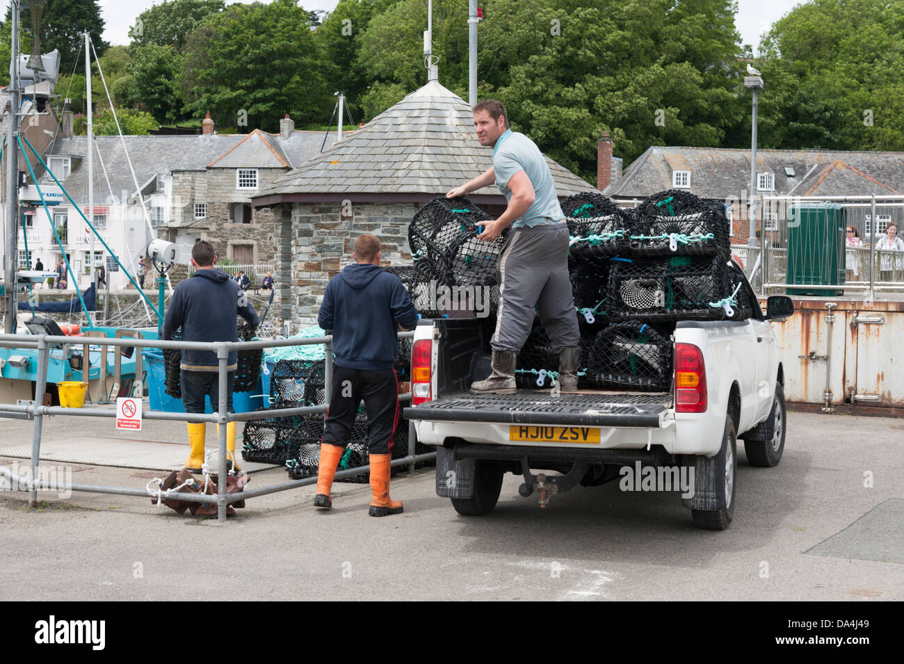 I pescatori lo scarico di nuovo o di granchio lobster pot in la banchina del porto di Padstow Cornwall Regno Unito Foto Stock