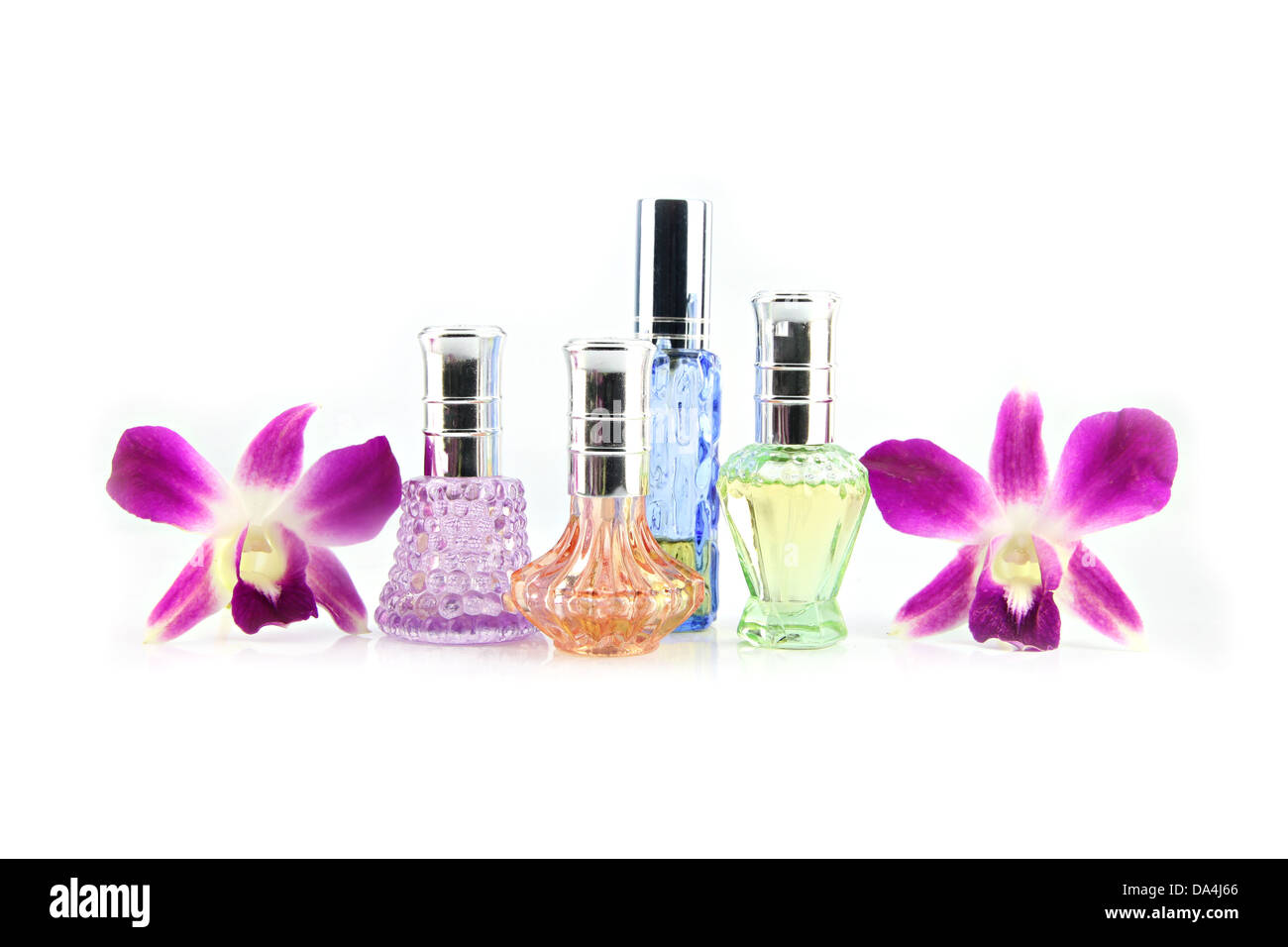 L'orchidea viola e bottiglie di profumo sullo sfondo bianco. Foto Stock