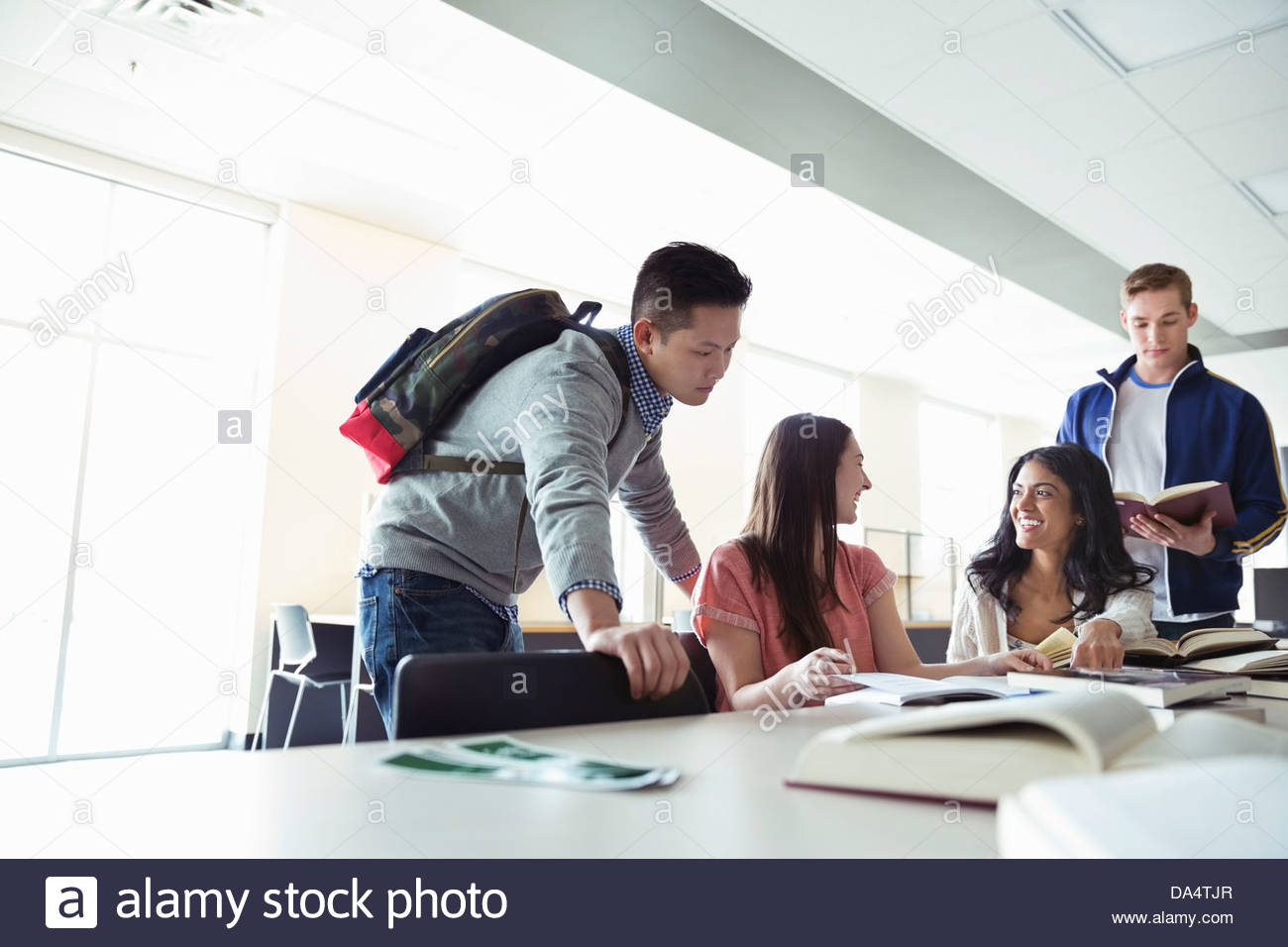 Gruppo di studenti a fare ricerche nella libreria di college Foto Stock