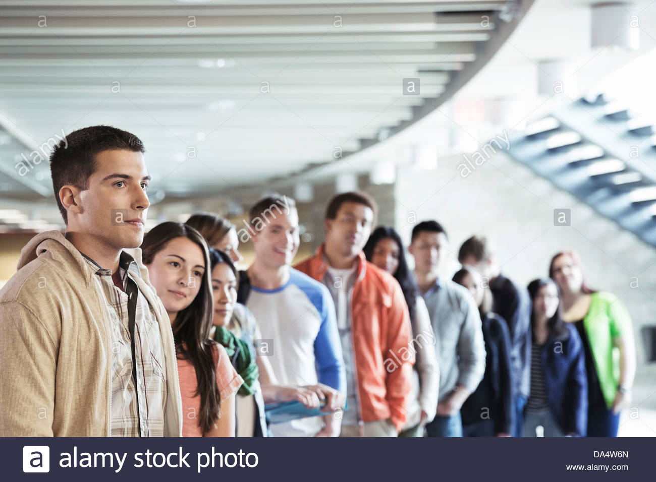 Un folto gruppo di studenti in piedi in linea al campus universitario Foto Stock