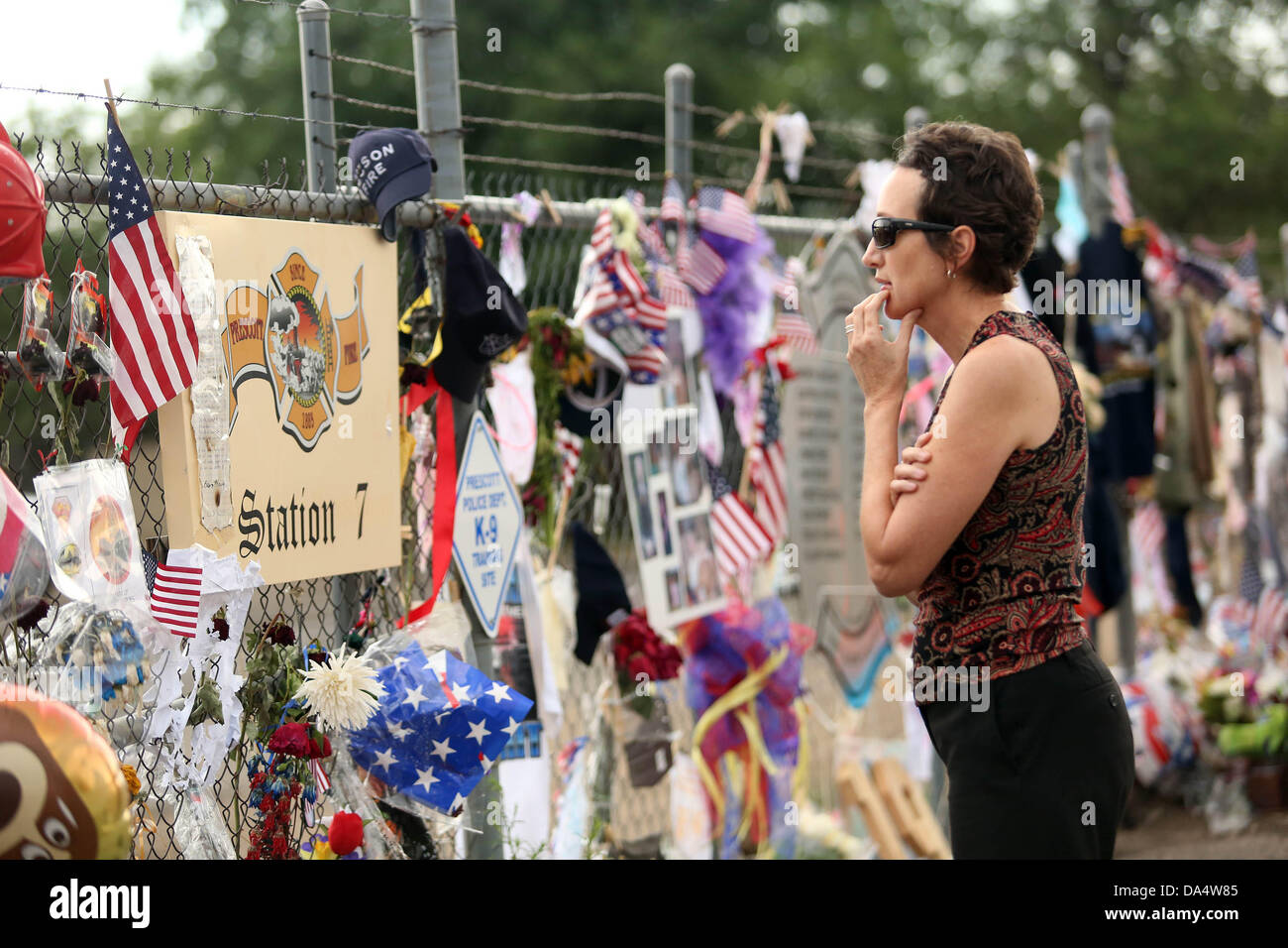 Prescott, AZ, Stati Uniti d'America. 3 Luglio, 2013. Una donna paga i suoi rispetti ai vigili del fuoco presso il sacrario dei caduti 19 vigili del fuoco al di fuori della montagna di granito Hotshots Fire Station 7 Prescott, Arizona. Il Yarnell Hill il fuoco che ha ucciso tutti ma uno stato di un 20-forte 'hotshot' team, è stata la più grande perdita di vigili del fuoco' vita poiché gli attacchi dell'11 settembre, e la maggior parte da un noi wildfire in 80 anni. Credito: Krista Kennell/ZUMAPRESS.com/Alamy Live News Foto Stock
