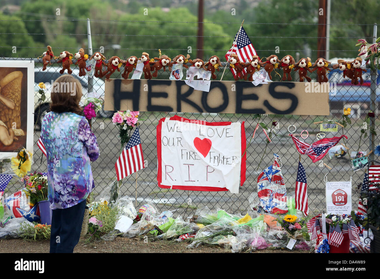 Prescott, AZ, Stati Uniti d'America. 3 Luglio, 2013. Una donna paga i suoi rispetti ai vigili del fuoco presso il sacrario dei caduti 19 vigili del fuoco al di fuori della montagna di granito Hotshots Fire Station 7 Prescott, Arizona. Il Yarnell Hill il fuoco che ha ucciso tutti ma uno stato di un 20-forte 'hotshot' team, è stata la più grande perdita di vigili del fuoco' vita poiché gli attacchi dell'11 settembre, e la maggior parte da un noi wildfire in 80 anni. Credito: Krista Kennell/ZUMAPRESS.com/Alamy Live News Foto Stock