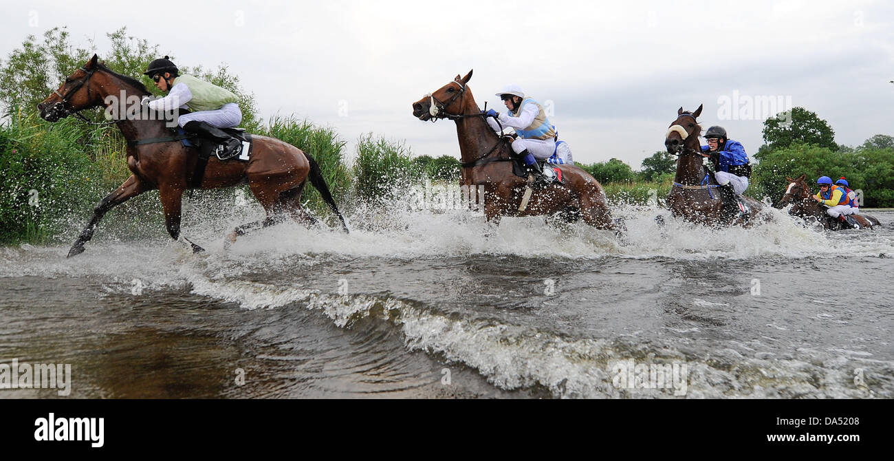 Amburgo, Germania. 03 Luglio, 2013. Cavalli e Cavalieri si traversa un ostacolo di acqua nel lago la gara di suoneria (Seejagdrennen) durante il equina sport galoppo derby incontro al racecourse Hamburg-Horn ad Amburgo, Germania, 03 luglio 2013. Foto: Axel HEIMKEN/dpa/Alamy Live News Foto Stock