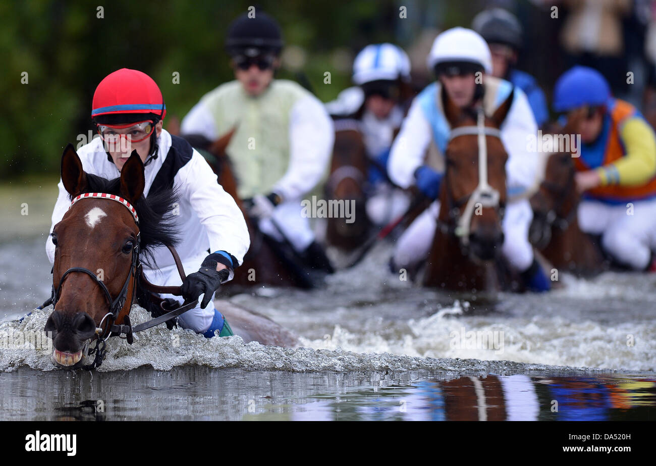 Amburgo, Germania. 03 Luglio, 2013. Vlastislav Korytar (L) sul sole indiano, vincitore del lago gara di suoneria (Seejagdrennen), conduce all'acqua ostacolo durante il equina sport galoppo derby incontro al racecourse Hamburg-Horn ad Amburgo, Germania, 03 luglio 2013. Foto: Axel HEIMKEN/dpa/Alamy Live News Foto Stock