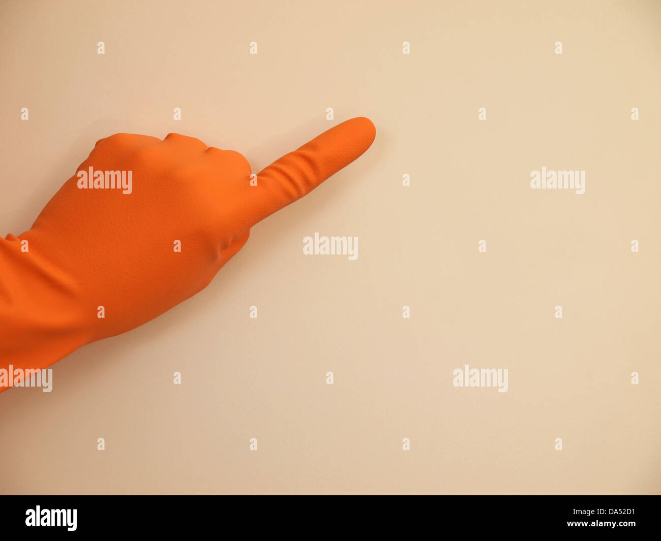 Mano con un guanto di gomma puntando su qualcosa, sfondo con spazio per il testo o immagine Foto Stock