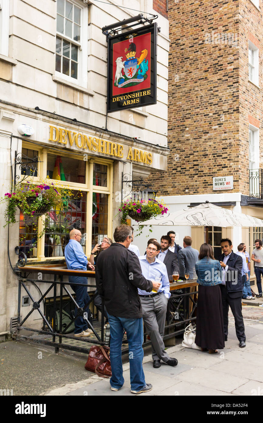 Patroni gustando un drink al di fuori presso il Devonshire Arms, Londra Foto Stock