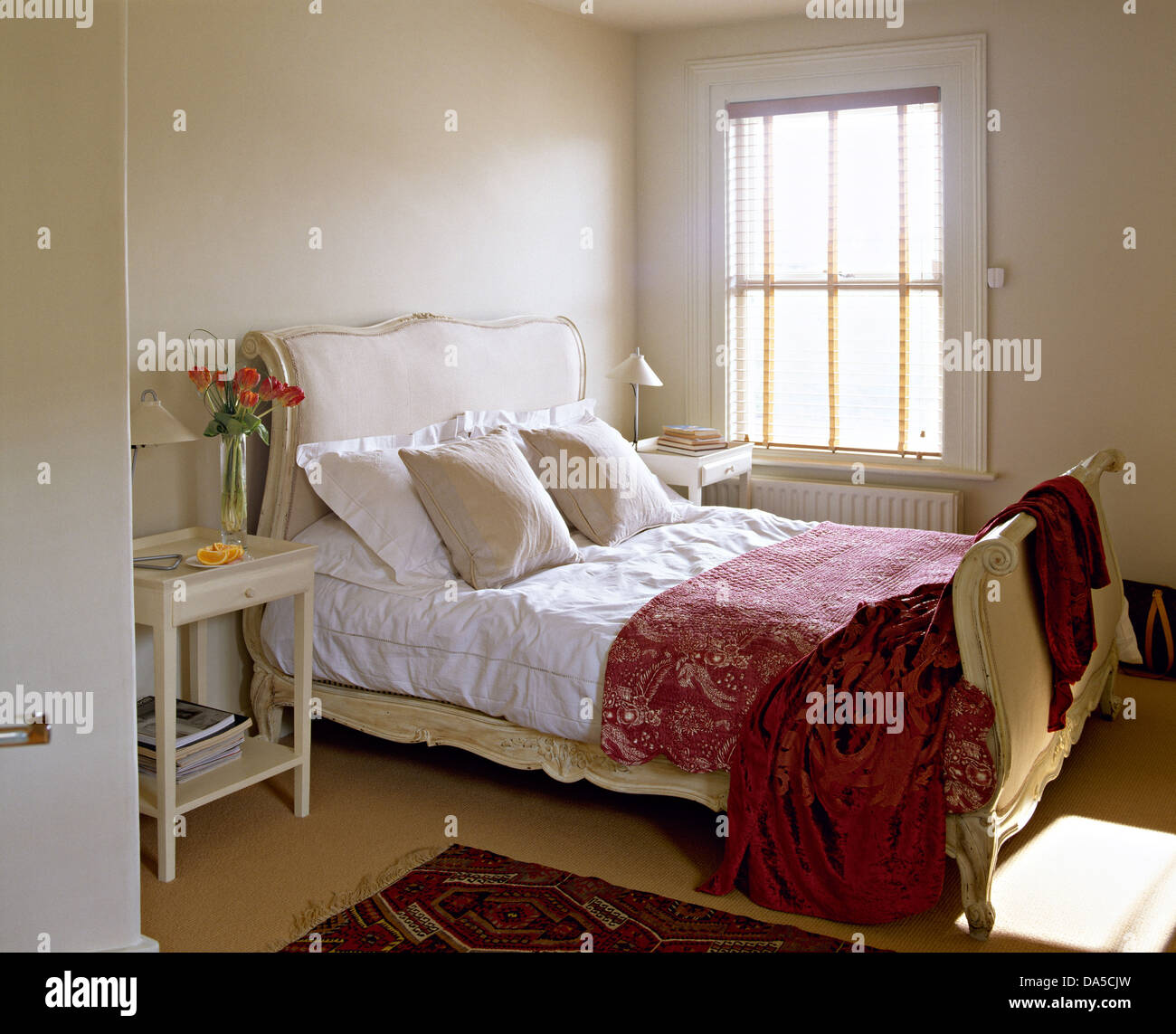 Velluto rosso a buttare sul letto alla francese con il bianco di cuscini e piumini in townhouse camera con letto dipinte di color crema comodino Foto Stock