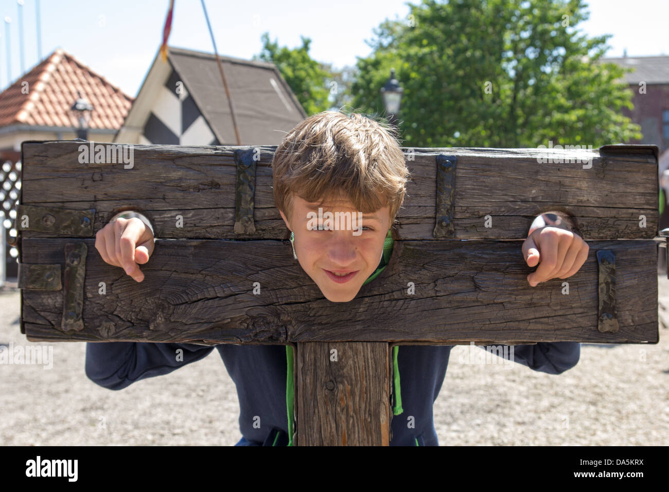 Un ragazzo intrappolato in una tortura medievale dispositivo Foto Stock