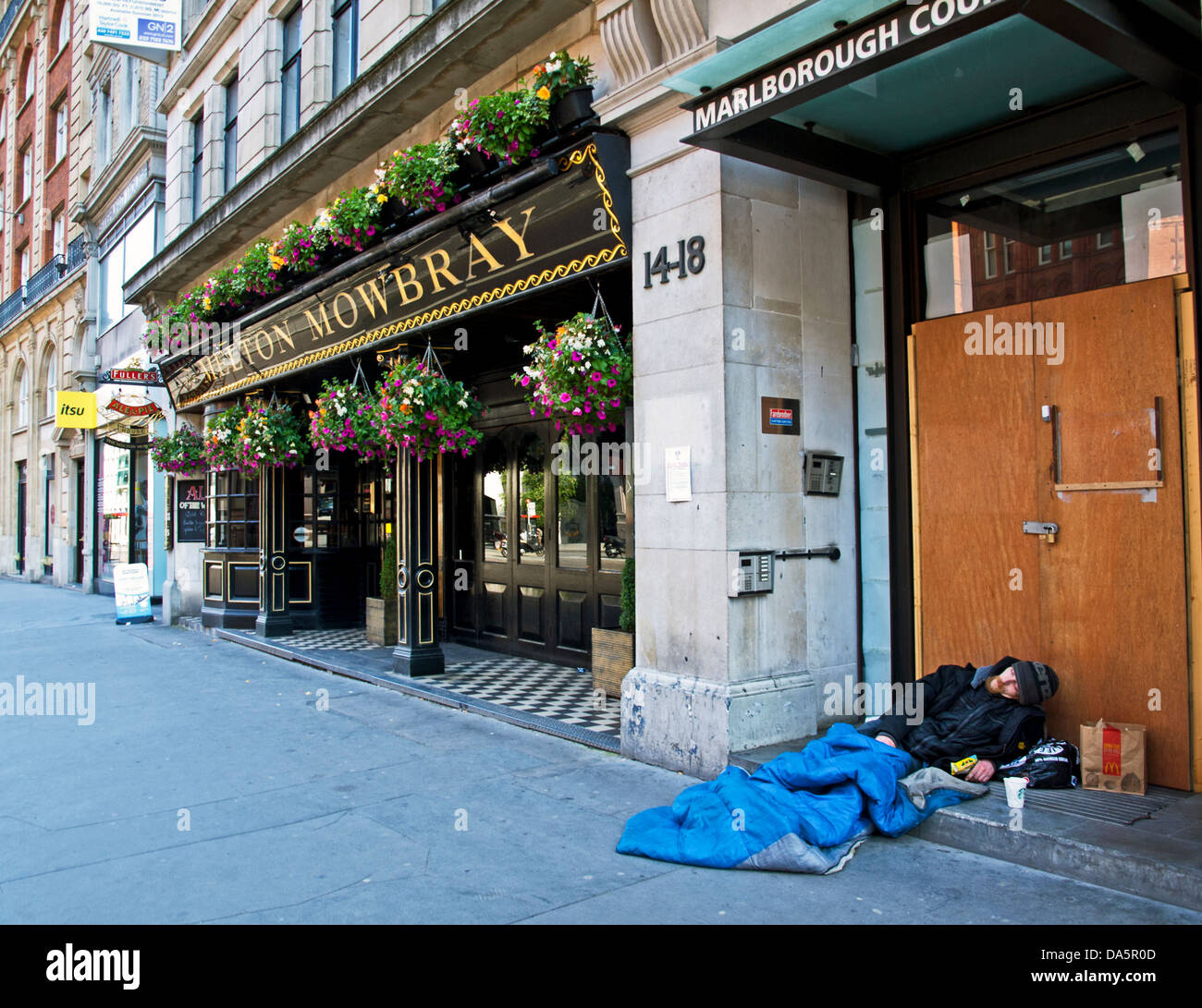 Senzatetto uomo addormentato al di fuori di un pub, Holborn, Londra, Inghilterra, Regno Unito Foto Stock