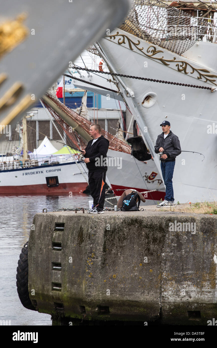 Aarhus, Danimarca. 4 Luglio, 2013. Due pescatori locali a continuare le attività di pesca non è influenzata dalla Tall Ships gare 2013 ad Aarhus in Danimarca. La città di Aarhus in Danimarca, è il punto di partenza di questo anni Tall Ships gare. La manifestazione prevede una flotta di 104 navi a vela e 3000 i membri dell'equipaggio provenienti da tutto il mondo. Credito: Michael Harder/Alamy Live News Foto Stock