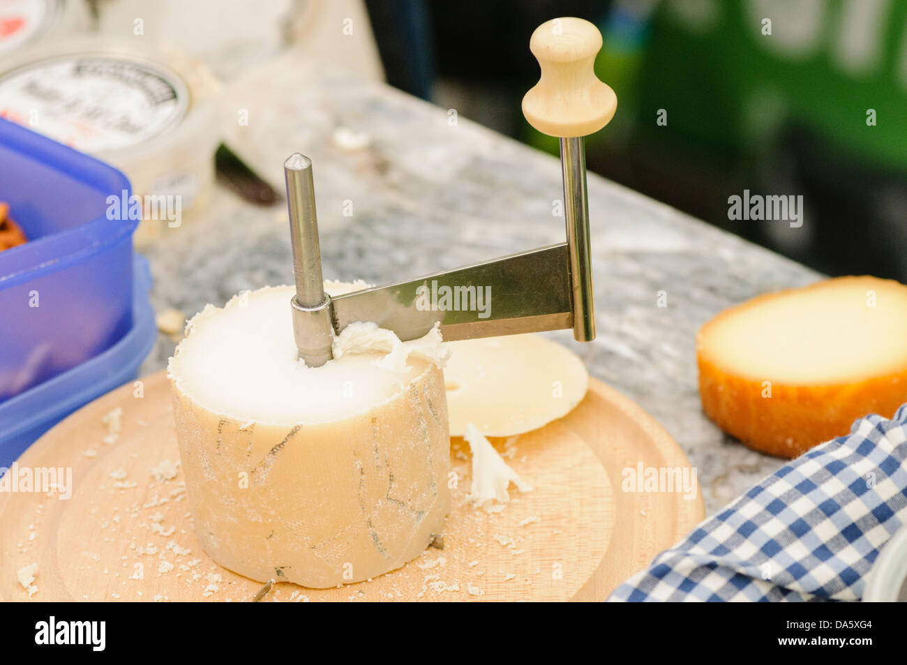 Un rotary Grattuggia formaggio su un round formaggio di pecora. Foto Stock