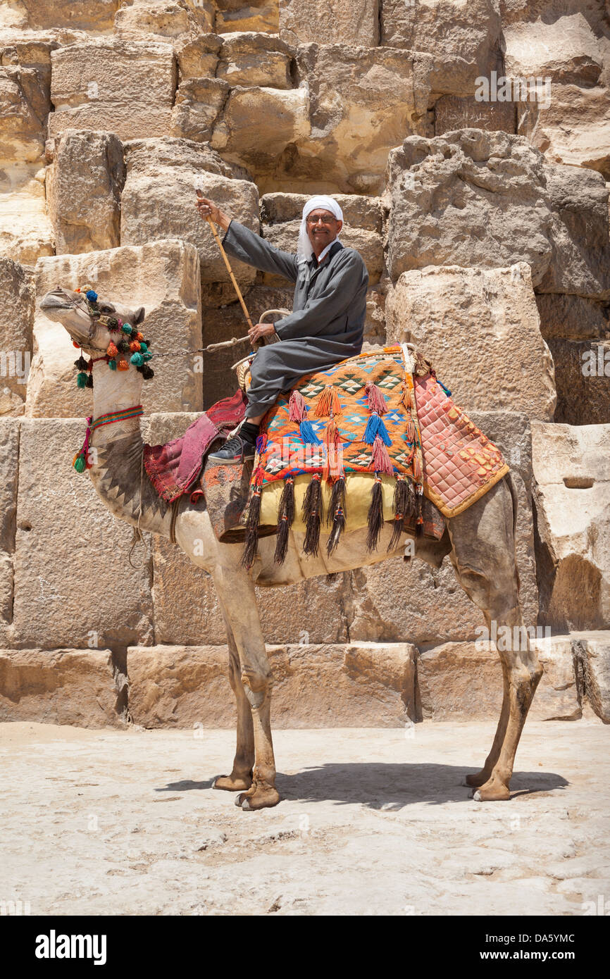 Uomo e cammello accanto alla grande Piramide di Giza, noto anche come piramide di Khufu e piramide di Cheope, Giza, il Cairo, Egitto Foto Stock