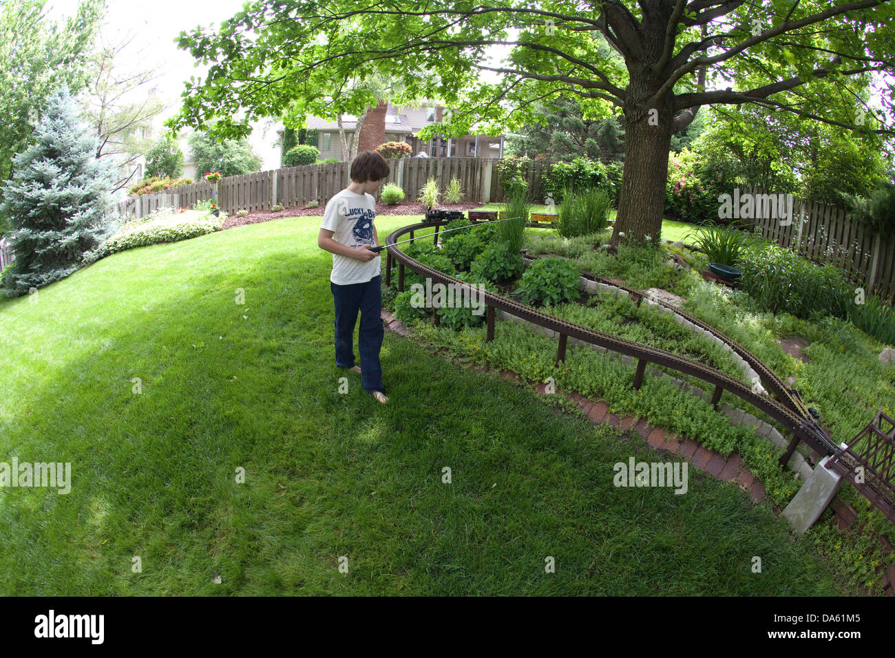 Ragazzo giocando con un modello di treno insieme all'esterno. Foto Stock